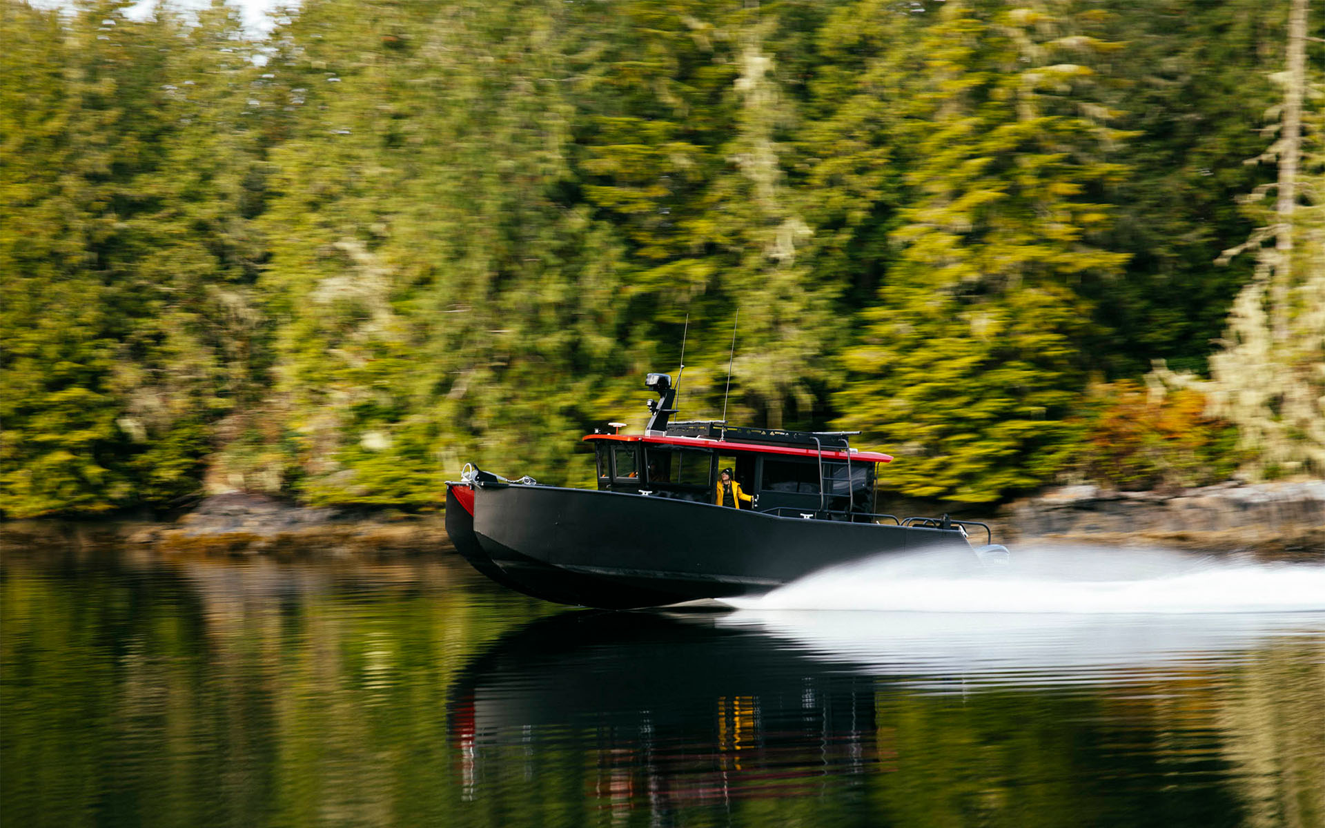 A coastal safari boat travelling through British Columbia wilderness